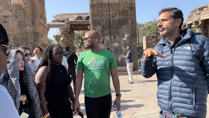 Local Indian firm representative Rishi explains to the overseas visiting students about the history of Qutab Minar.